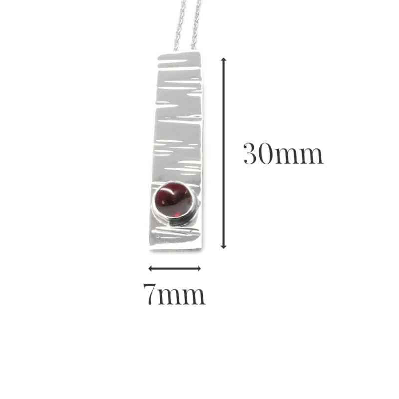 Sterling silver and 5mm Garnet pendant featuring the bark texture. This pendant comes complete with a 16-18″ sterling silver chain.