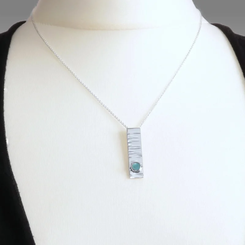 Sterling silver and 5mm Turquoise pendant featuring the bark texture. This pendant comes complete with a 16-18″ sterling silver chain.