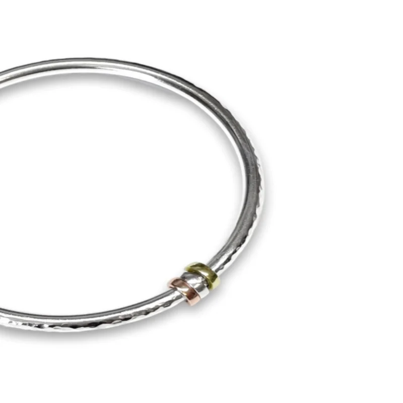 Sterling silver bangle with Brass, Silver and Copper charms. Available in 4 sizes.