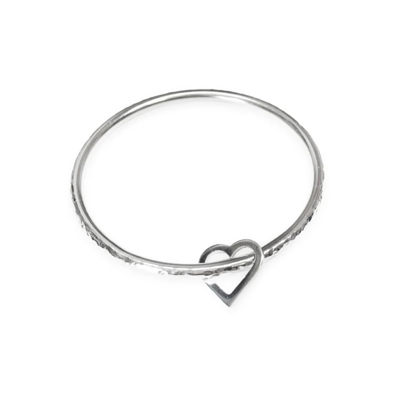 Sterling silver bangle with dimple texture and sterling silver heart charm. Available in 4 sizes.