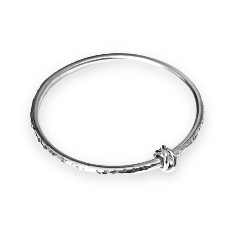 Sterling silver bangle with dimple texture and sterling silver russian knot charm. Available in 4 sizes.