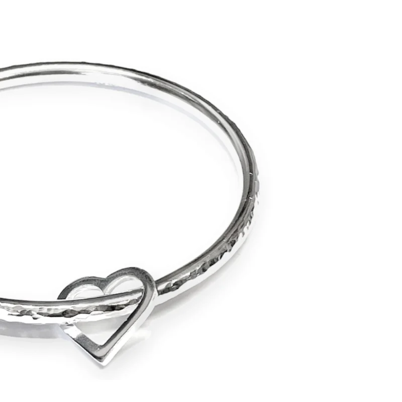 Sterling silver bangle with dimple texture and sterling silver heart charm. Available in 4 sizes.