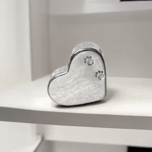 Sterling silver heart memorial box with paw prints stamped on front.