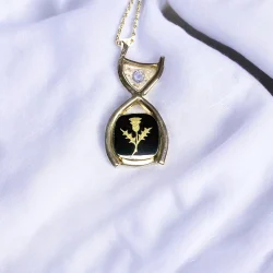 9ct gold pendant with a Black Onyx with carved thistle and ashes in resin. Made using clients gold and gemstones.